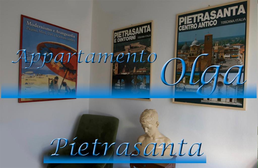 ピエトラサンタにあるOlgaの椅子付きの壁にポスターが掛けられた部屋