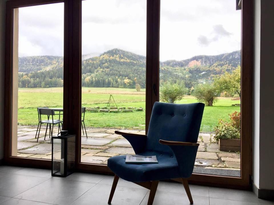 une chaise bleue assise devant une fenêtre dans l'établissement Centrum Łąkowa 1, à Radków