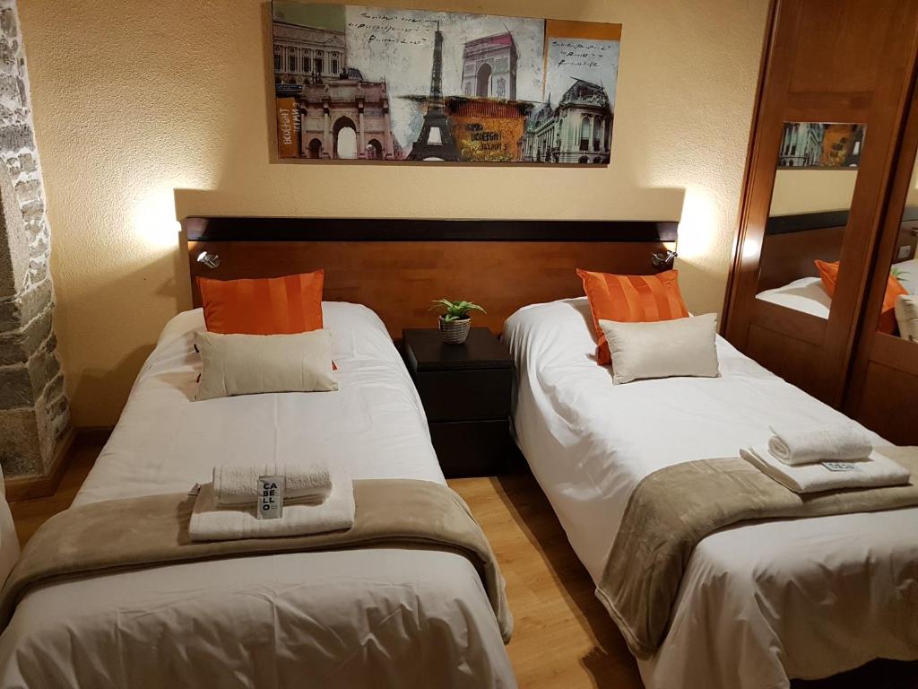 una habitación de hotel con 2 camas en una habitación en Aqua Rooms Sarria, en Sarria