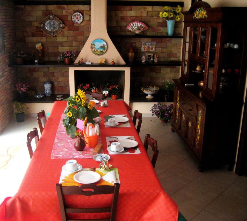 スフェッラカヴァッロにあるBed&Breakfast Il Golfoの赤いテーブルと暖炉付きのダイニングルーム