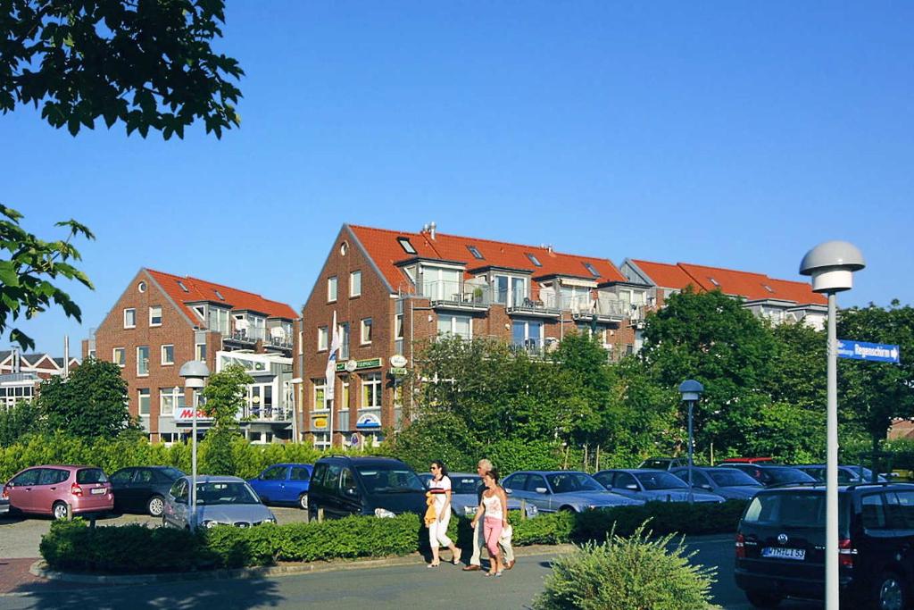 twee vrouwen die over een straat lopen op een parkeerplaats bij Apartments im Nordseegartenpark in Bensersiel