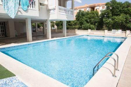 einem großen Pool vor einem Gebäude in der Unterkunft CHEMA'S HOME in Santa Pola