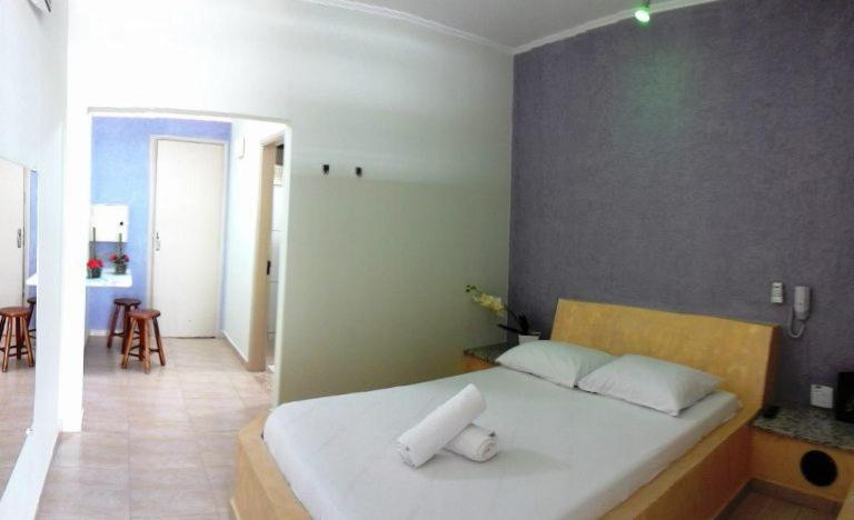 una camera con un letto con due cuscini sopra di Motel Kokeluxe a Cachoeira Paulista