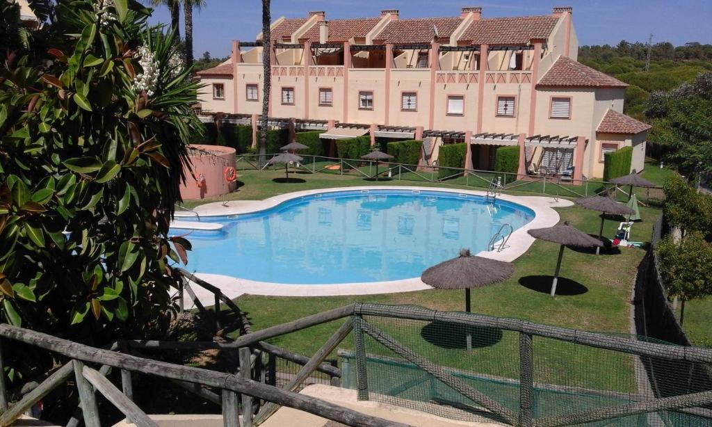 a swimming pool in front of a large building at Residencial Augusta in Islantilla