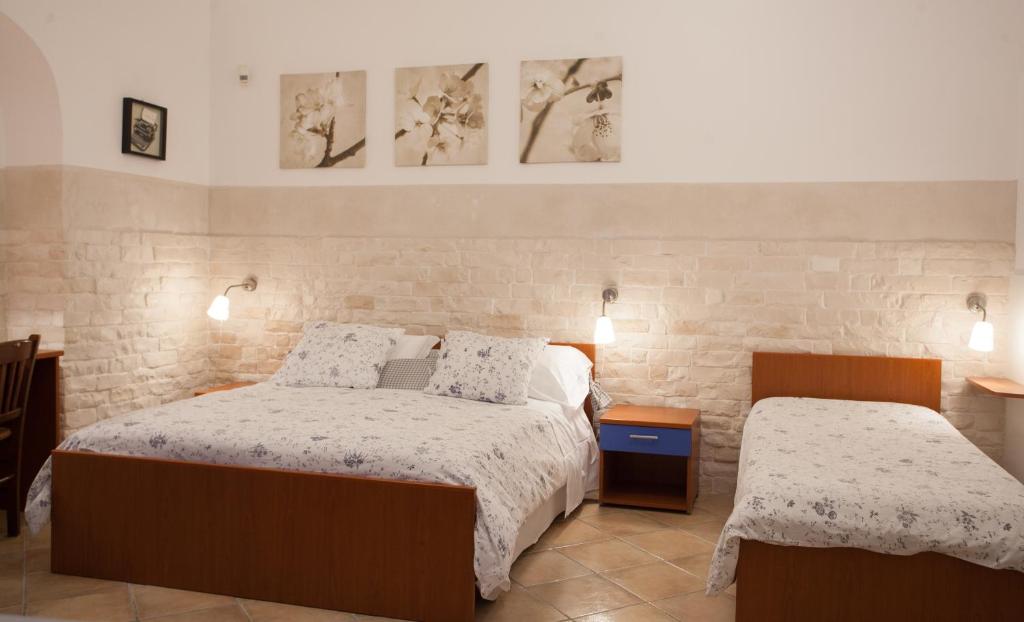 a bedroom with two beds and two pictures on the wall at Trio D'Archi - La Maison de Cocò in Caltagirone