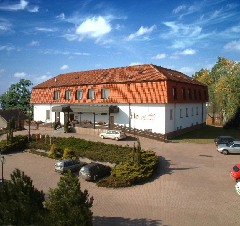 duży budynek z samochodami zaparkowanymi na parkingu w obiekcie Hotel Panorama w Pilznie