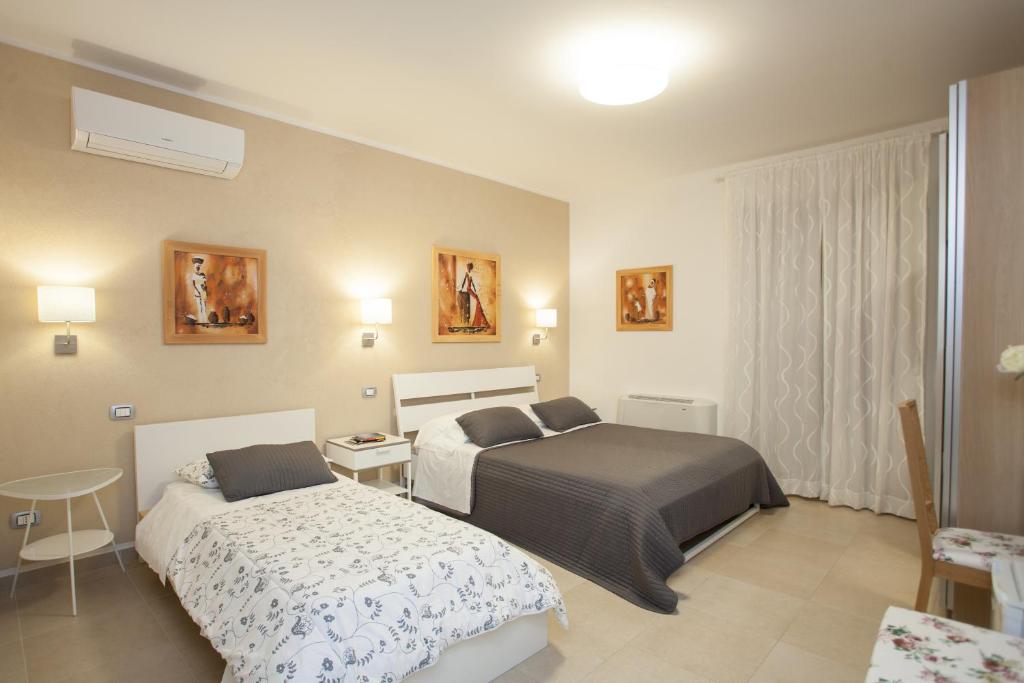 カルタジローネにあるTrio D'Archi - Elegant Loft Caltagironeのベッド2台とテーブルが備わるホテルルームです。