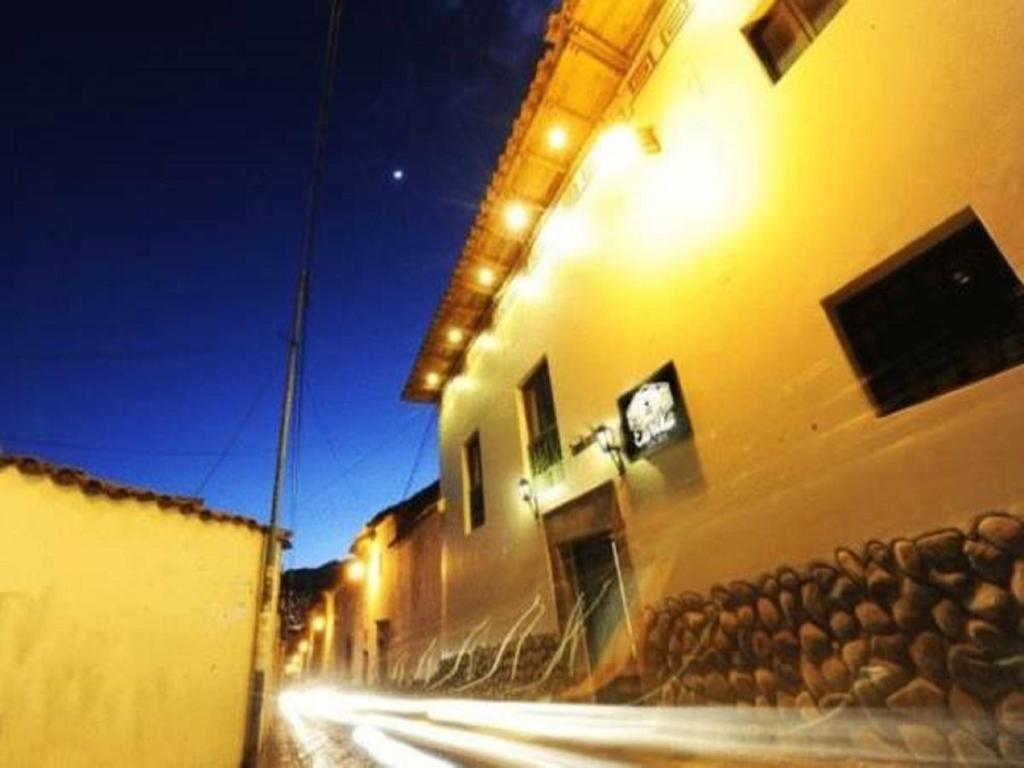a building with lights on the side of a street at Eureka San Blas in Cusco