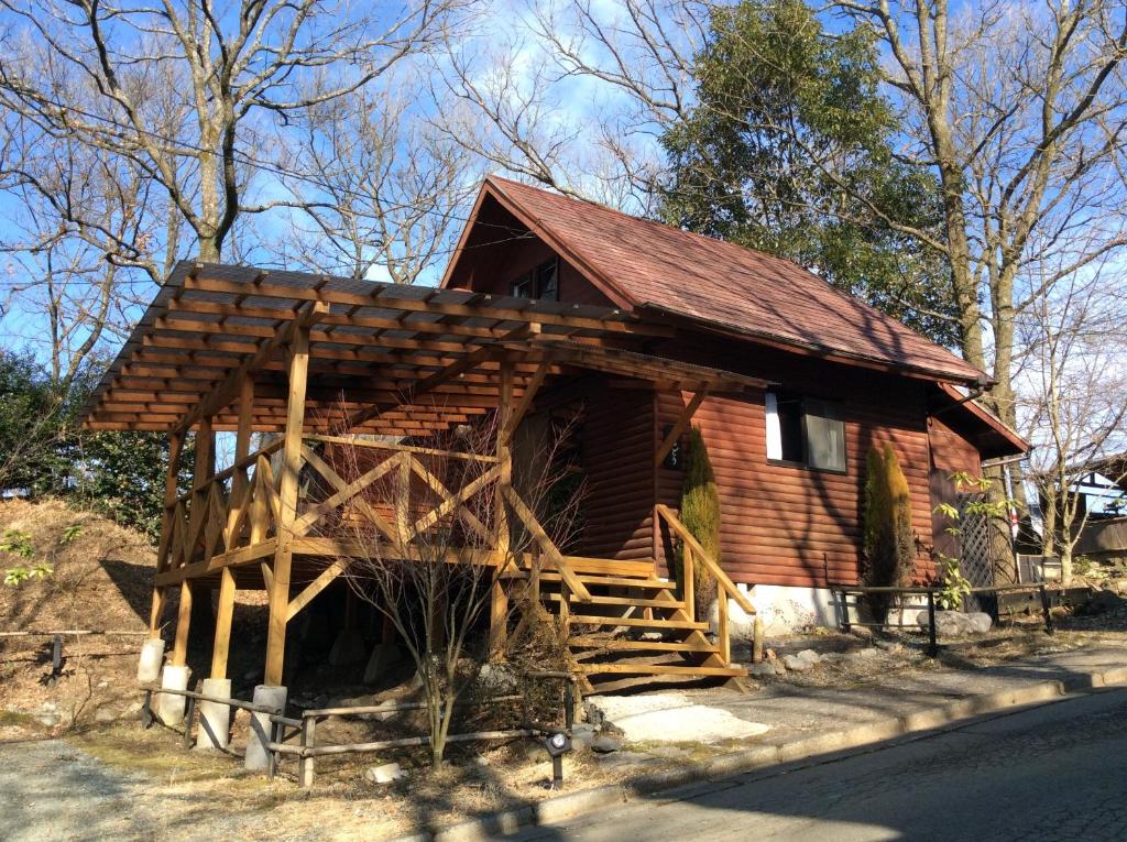 a small log cabin with a wooden roof at Kurasako Onsen Sakura in Minamioguni