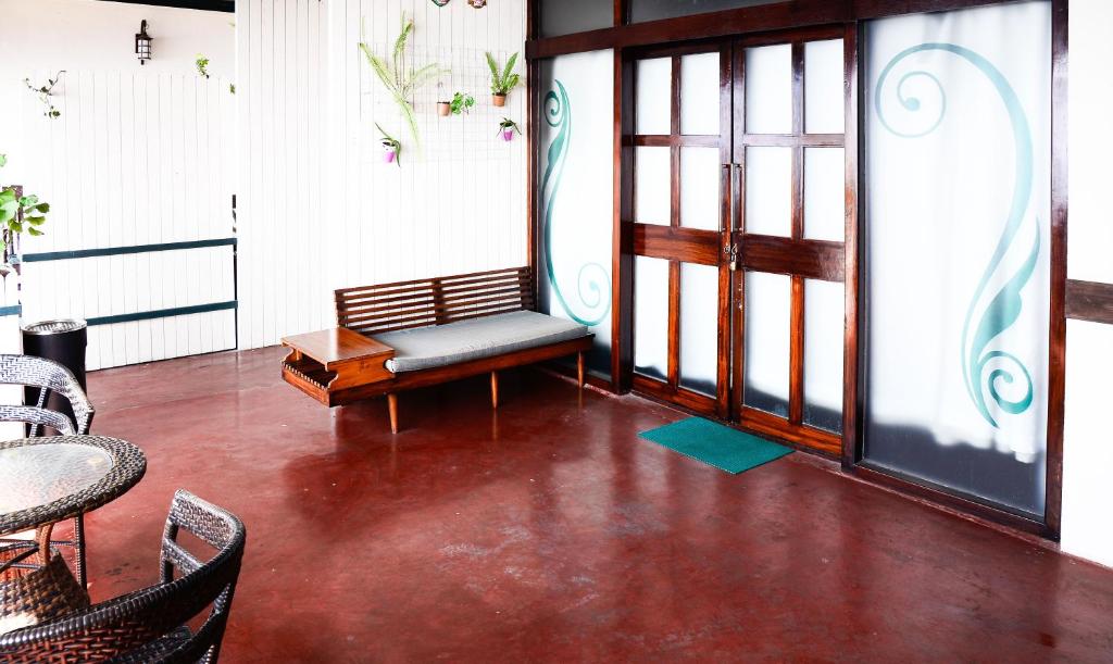 a room with a bench and a table and chairs at The Nettle and Fern Hotel Gangtok in Gangtok