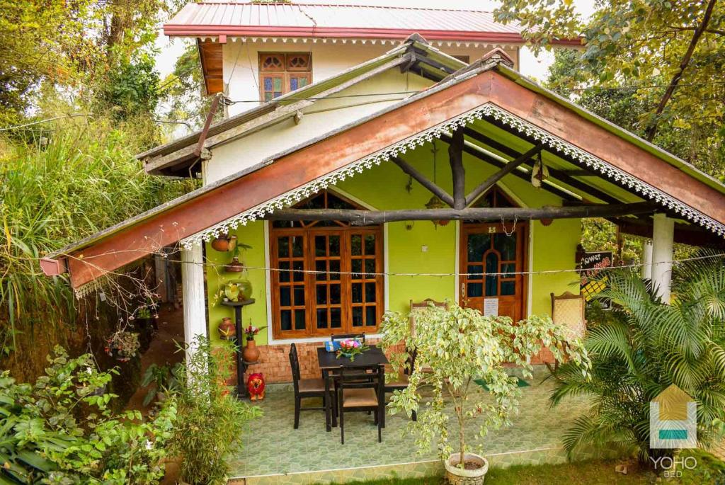 a small yellow house with a table in front of it at Sudumal Cottage in Ella