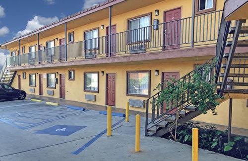 um edifício com varandas e escadas num parque de estacionamento em Satellite Motel, Los Angeles - LAX em South Los Angeles