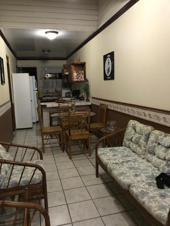 a living room with a couch and chairs and a kitchen at Ruiselares in Puntarenas