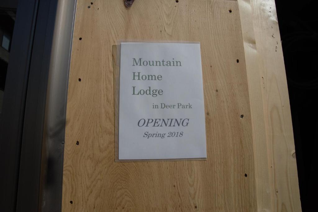 a sign on a wooden door with a sign on it at Mountain Home Lodge in Deer Park in Nara