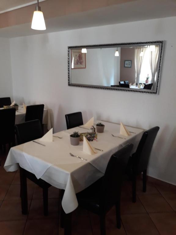 uma sala de jantar com uma mesa com cadeiras e um espelho em Hotel Restaurant Stern em Mannheim