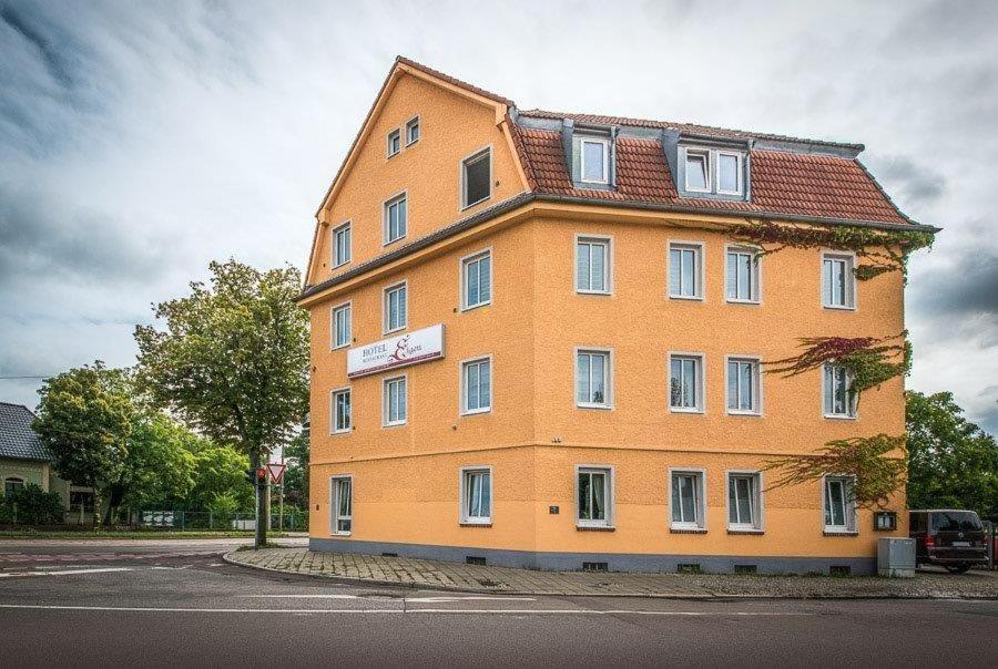 ein großes orangefarbenes Gebäude an der Seite einer Straße in der Unterkunft Hotel Eigen in Halle an der Saale