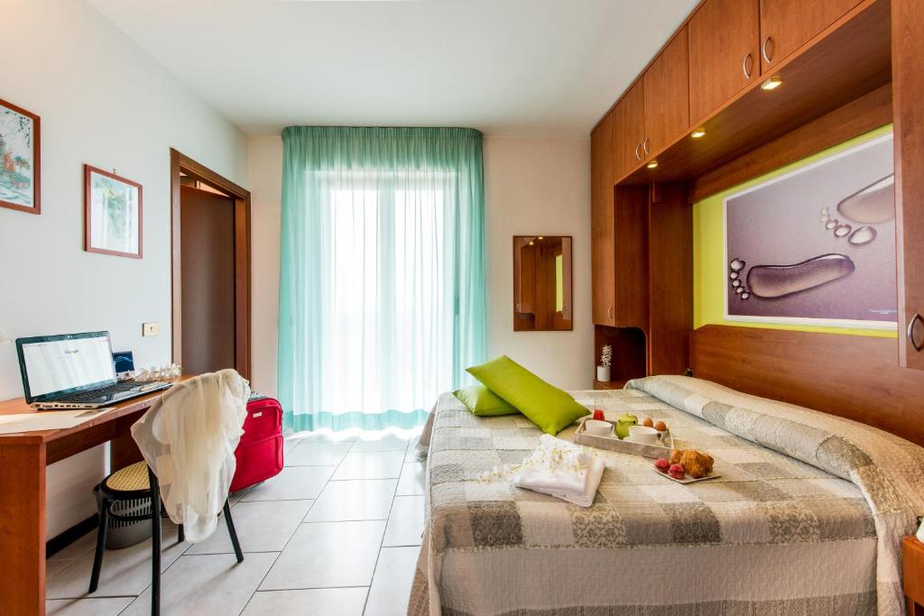 a bedroom with a bed and a desk at Hotel Villa Truentum in Martinsicuro