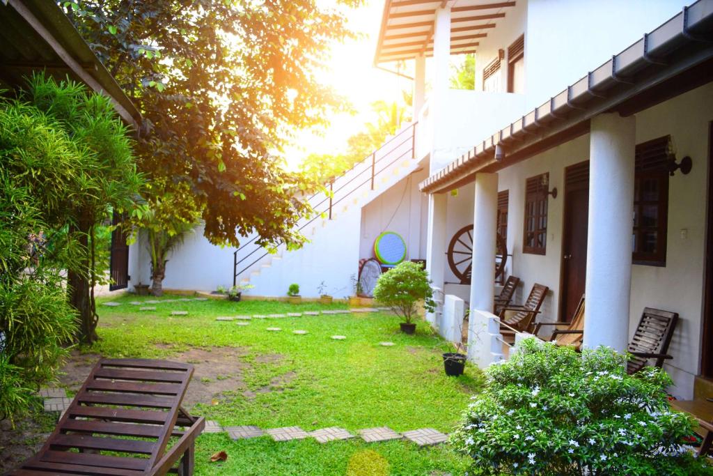 ein Hof eines Hauses mit Stühlen und Gras in der Unterkunft Surfing Life in Ahangama