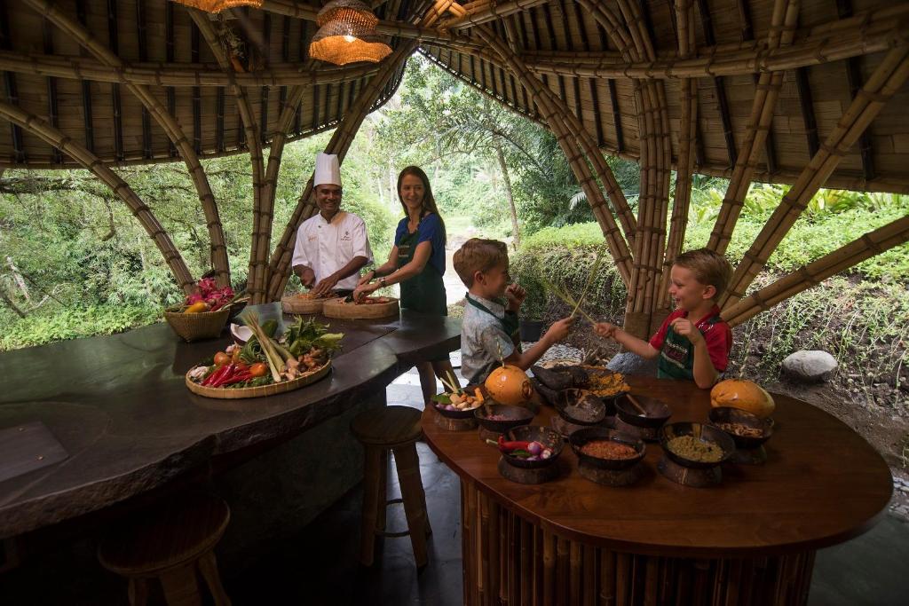 a group of children sitting at a table with food at Four Seasons Resort Bali at Sayan in Ubud