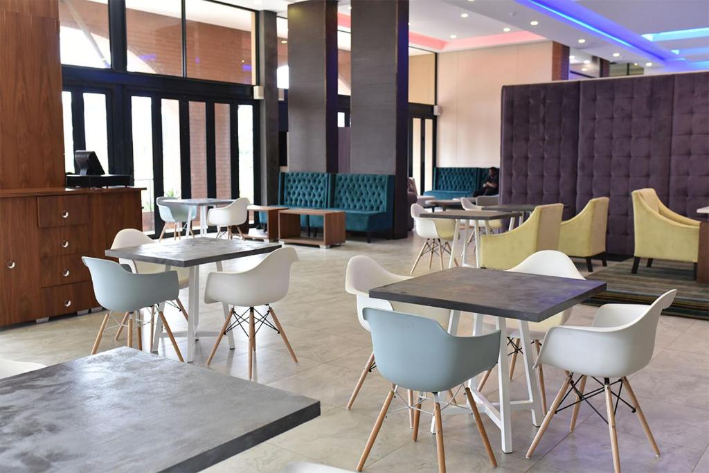un comedor con mesas y sillas en un restaurante en Regal Inn Umhlanga Gateway en Durban