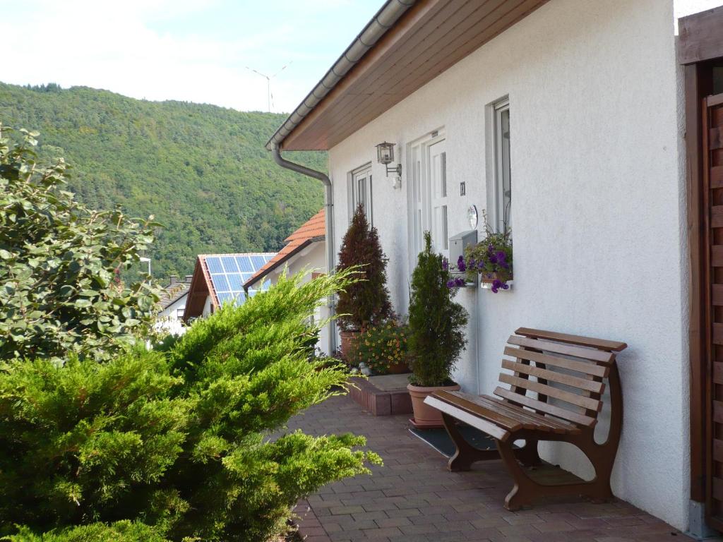 eine Holzbank auf der Seite eines Gebäudes in der Unterkunft Ferienwohnungen Meindl in Idar-Oberstein