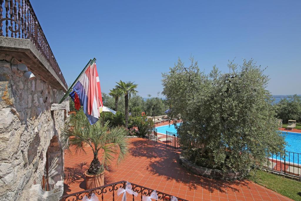 a resort with a swimming pool and a flag at San Rocco Relais in Soiano del Lago