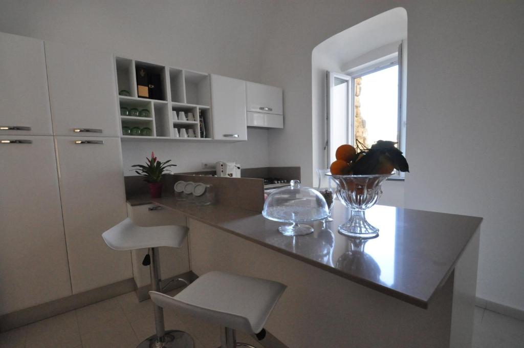 a kitchen with a counter with a bowl of fruit on it at Terra Murata Boutique b&b in Procida