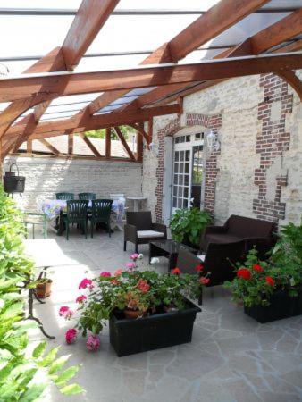 a patio with chairs and tables and flowers at Moulin de Chappes in Chappes