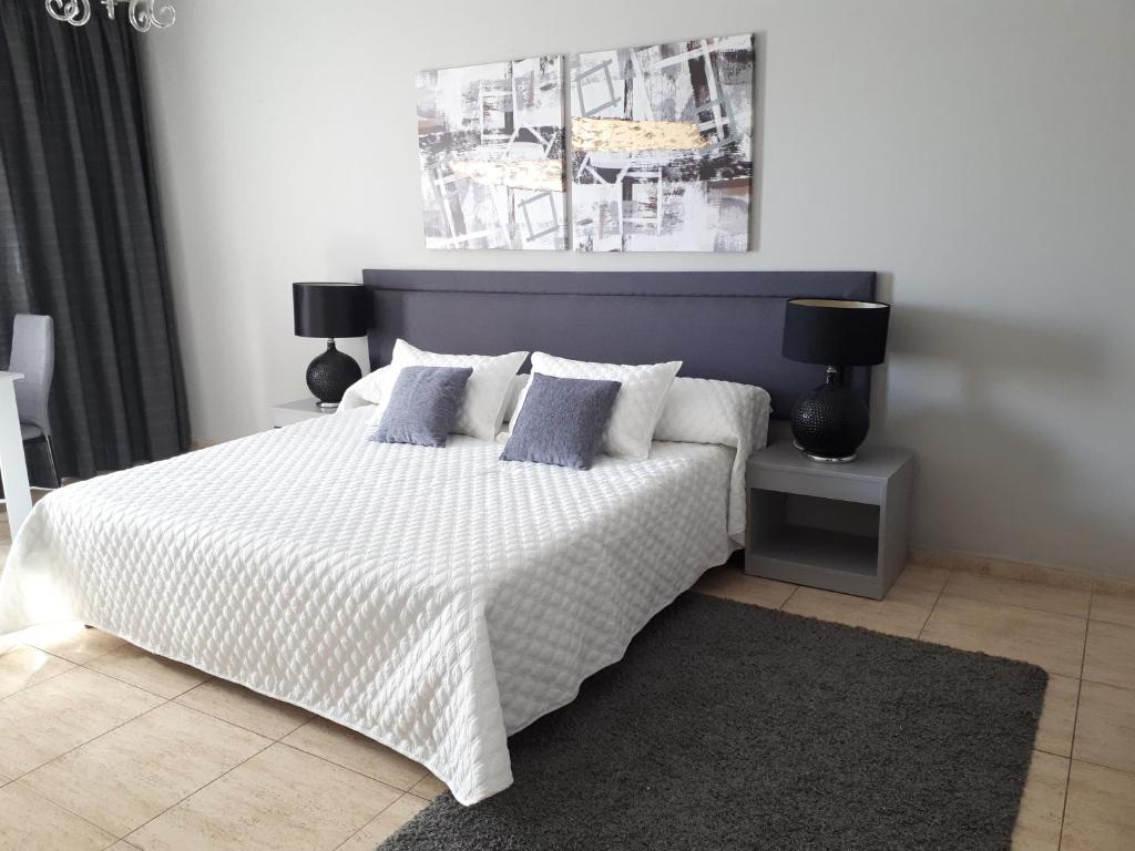 1 dormitorio con 1 cama blanca grande con almohadas en Irene's Apartments en Limassol