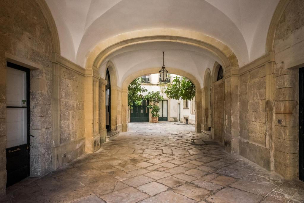 an empty hallway in an old building with an archway at Palazzo Bernardini Suites in Lecce