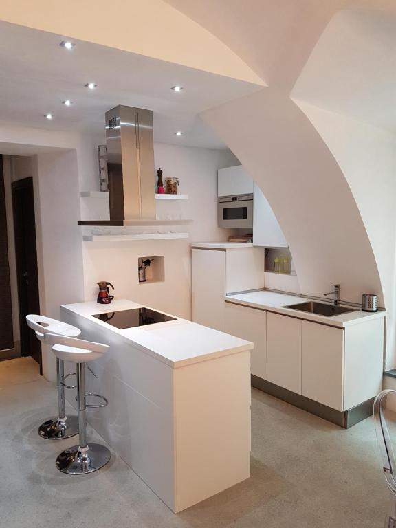 a kitchen with white cabinets and a white counter top at Ca' Irri Apartment in Baveno