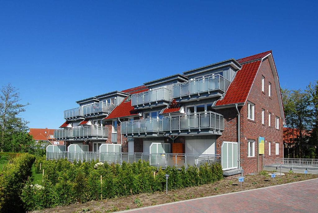 ベンサージールにあるFerienwohnung Inselstern - Residenz an der Nordseethermeのバルコニー付きの建物