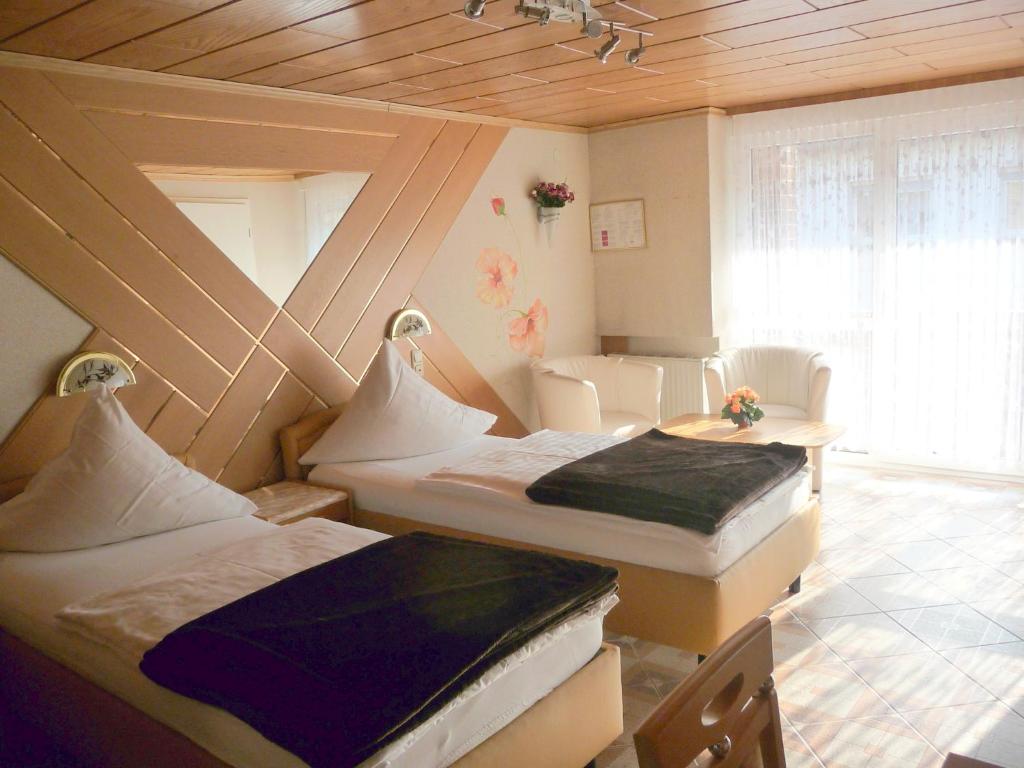 Cette chambre comprend 2 lits et une table. dans l'établissement Central Hotel, à Schwetzingen