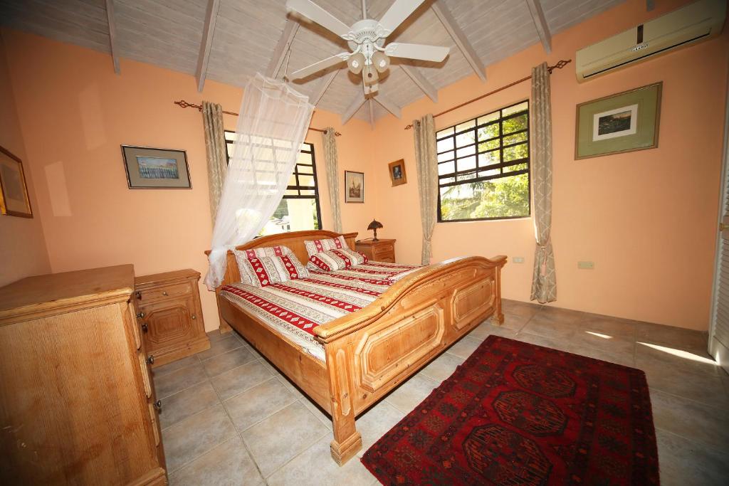 a bedroom with a wooden bed and a window at Eumelvilla in Saint James