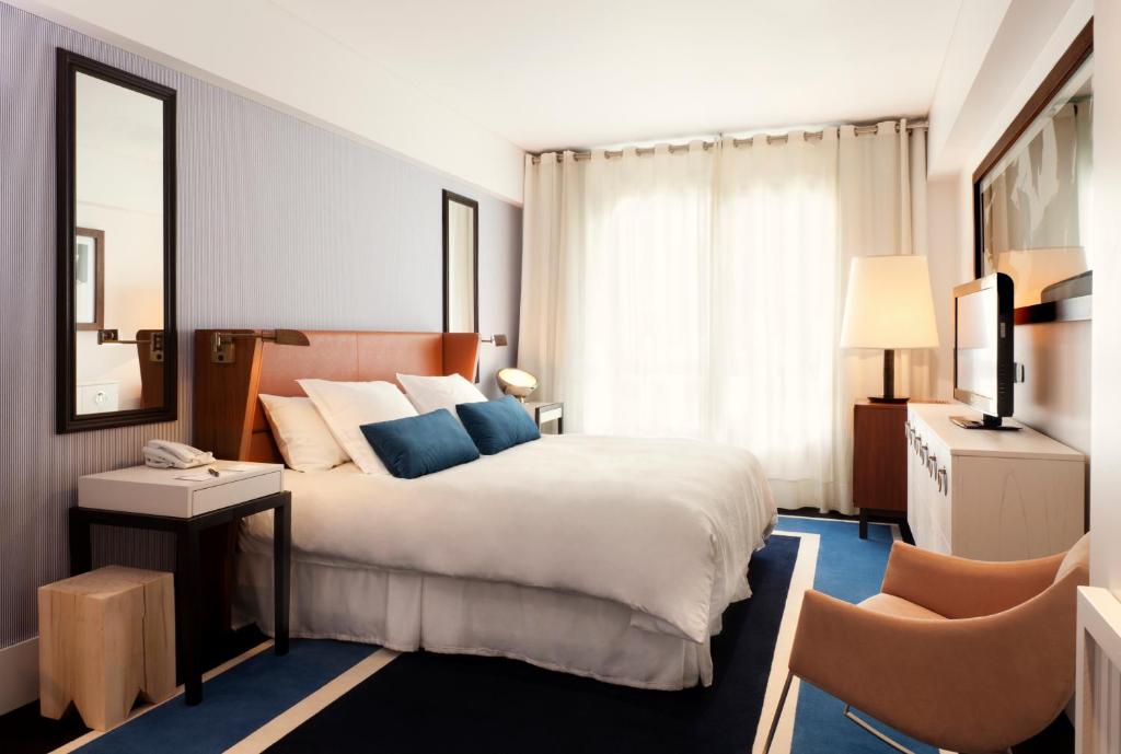 a bedroom with a large bed and two chairs at Hotel Pulitzer Buenos Aires in Buenos Aires