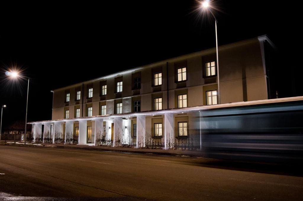 un edificio de noche con un autobús delante en Fidelitas Hotel en Sfântu-Gheorghe