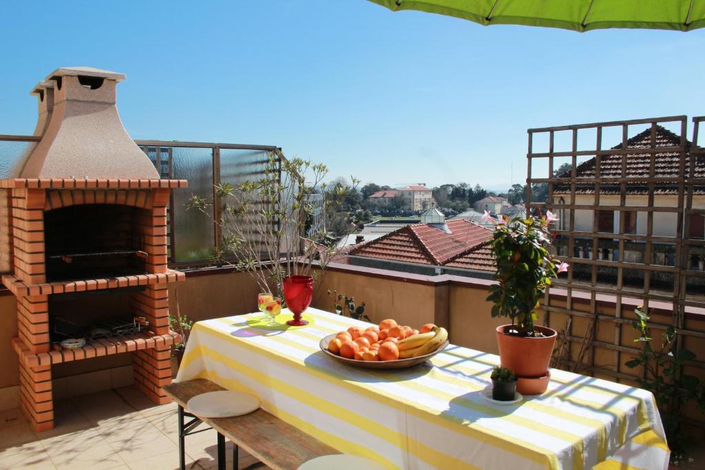 uma mesa com uma tigela de fruta numa varanda em Pretty flat with terrace, air cond, free parking em Porto
