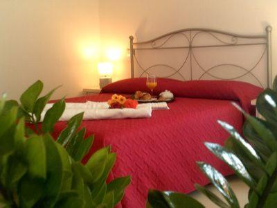 1 dormitorio con cama roja y manta roja en La casa di Giovanni e Angela, en Alghero