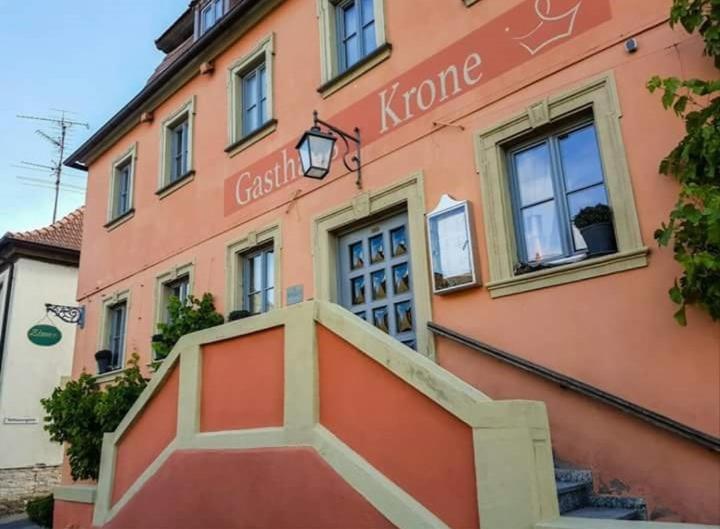 a pink building with a staircase in front of it at Gasthaus Krone in Wiesentheid