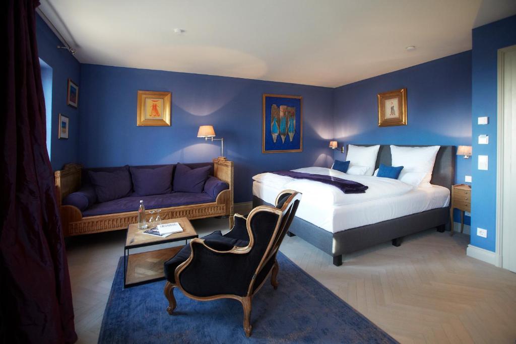 a bedroom with a king sized bed and a couch at Auberge de Temple in Johannesberg