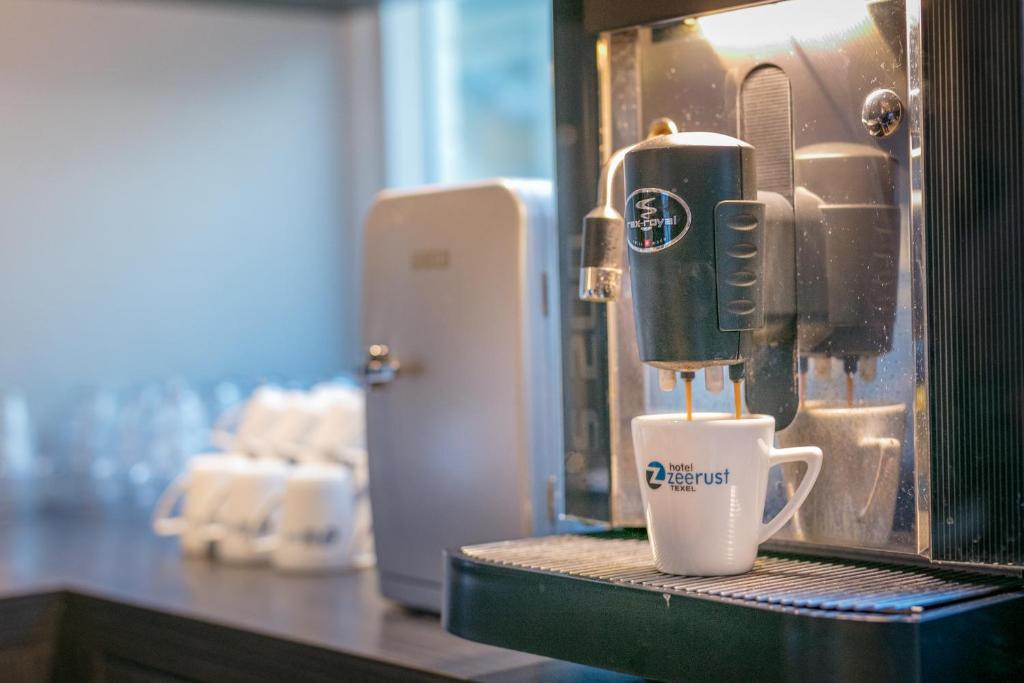 a coffee machine sitting on a counter with a cup at Hotel Zeerust Texel in De Koog