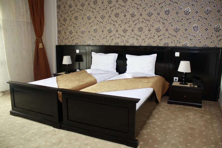 um quarto com uma cama grande e almofadas brancas em Hotel Imperium em Suceava