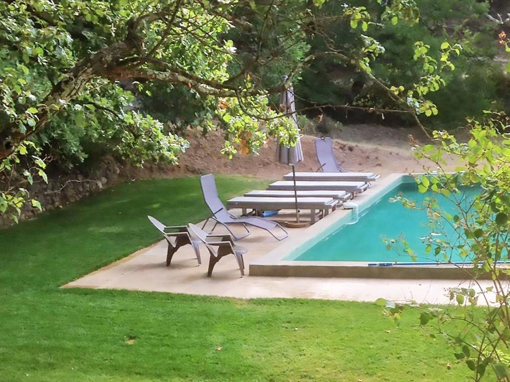 um grupo de cadeiras e uma piscina em Beautiful riverside villa in Entrecasteaux em Entrecasteaux