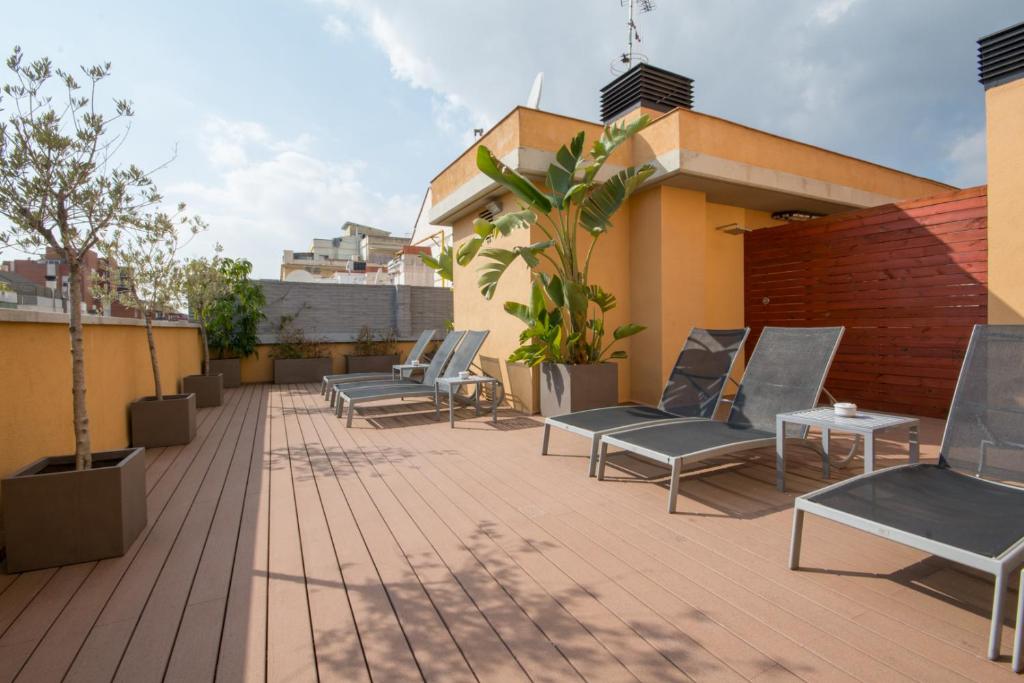 a patio with chairs and tables on a building at Sensation Authentic Gràcia in Barcelona