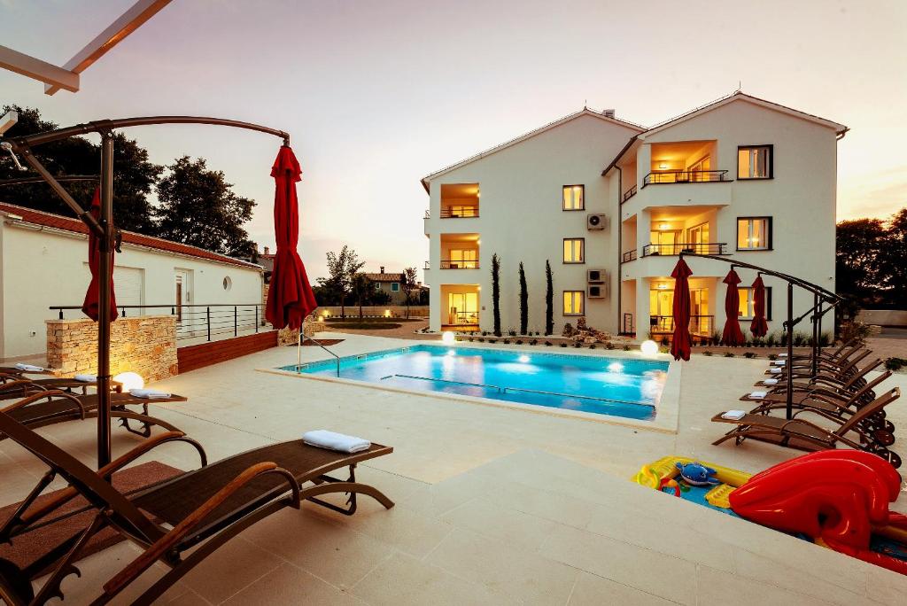 a house with a swimming pool in front of a house at Villa Anja in Peroj