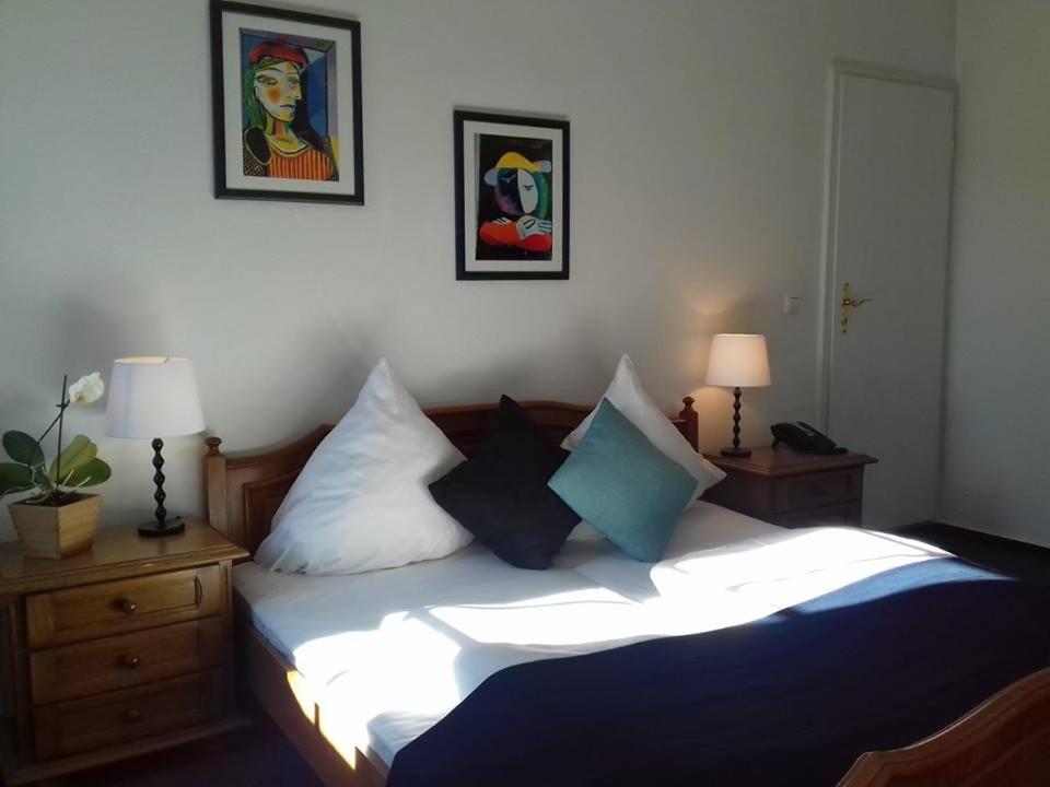 Schlafzimmer mit einem Bett mit blauen und weißen Kissen in der Unterkunft Badischer Hof in Mannheim