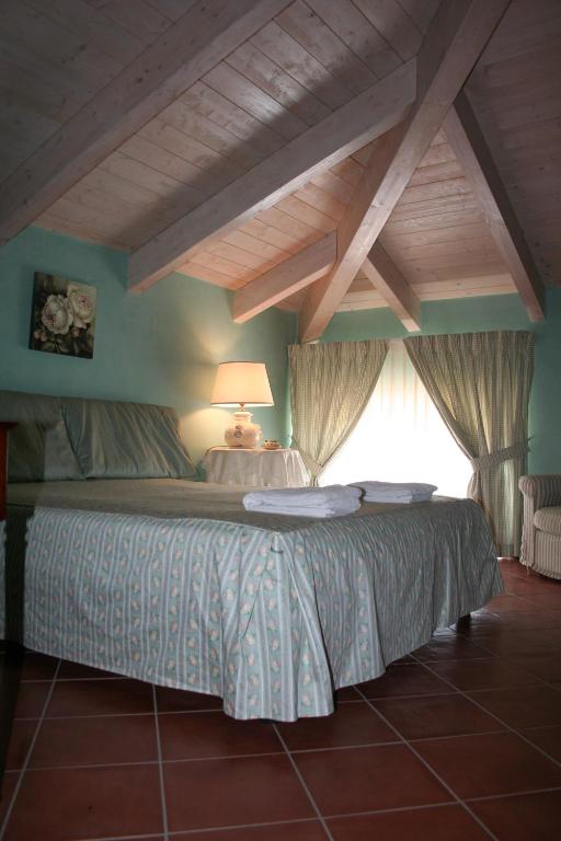 sypialnia z dużym łóżkiem i oknem w obiekcie B&B Macchia d'Olmo w Capaccio-Paestum