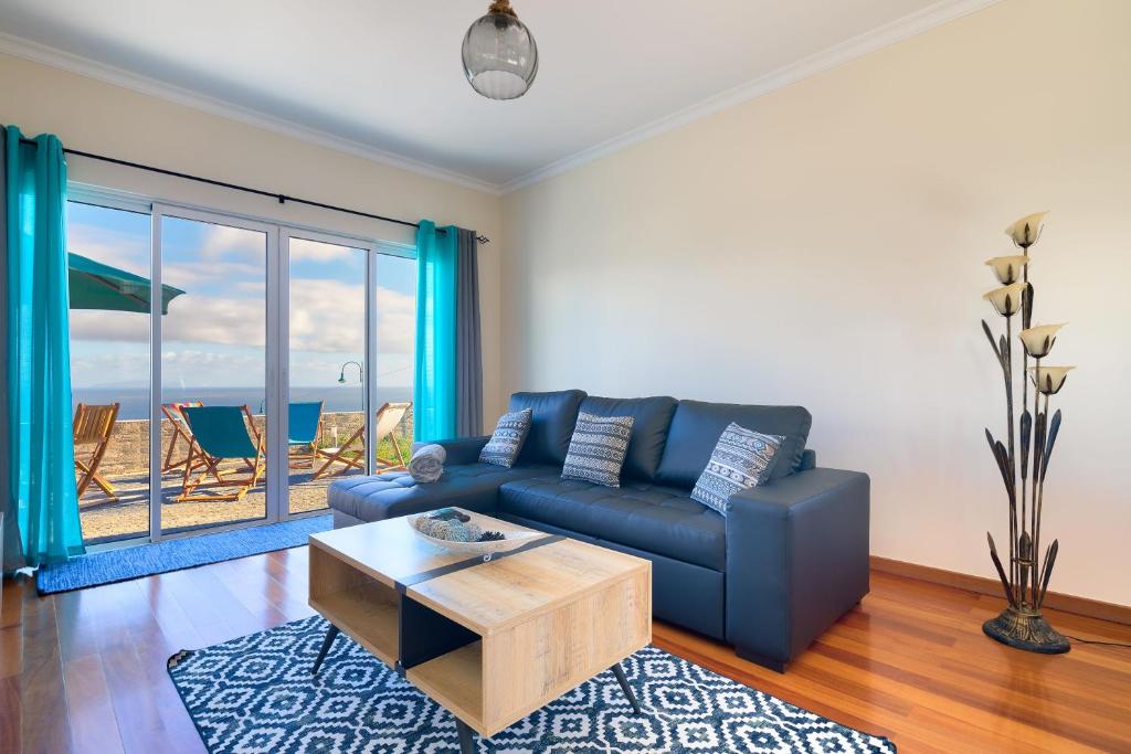 a living room with a blue couch and a table at Villa Araujo Da Costa by HR Madeira in Garajau