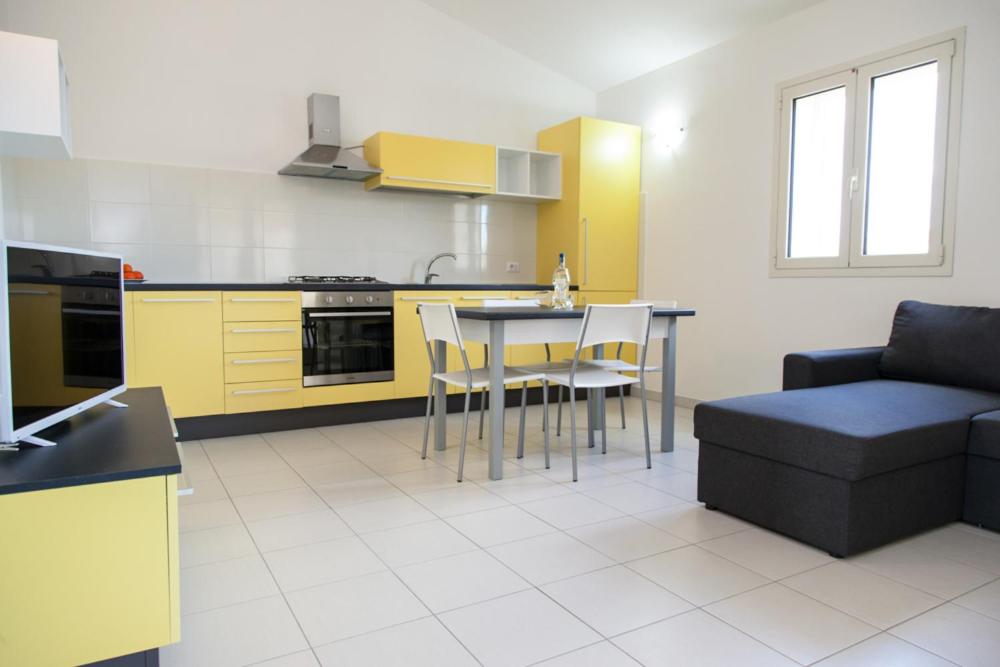 a kitchen with a table and chairs and a couch at San Teodoro in San Teodoro