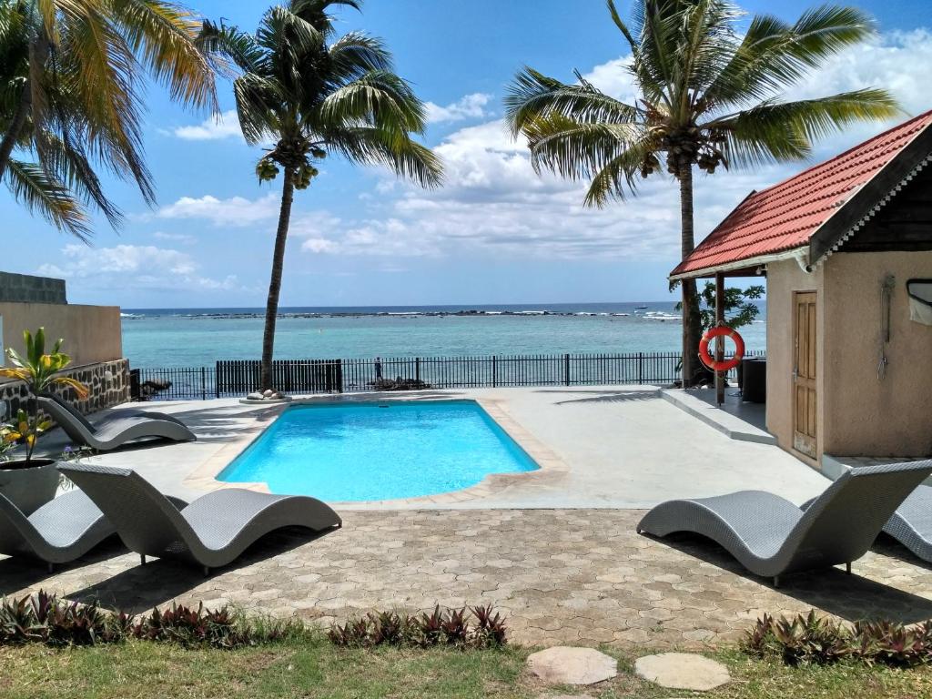 a swimming pool with a view of the ocean at Villasun Beachfront Villa in Flic-en-Flac